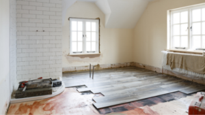 Room with wooden floors and a window, being remodeled for a fresh look.