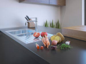 A kitchen counter equipped with a sink, displaying a collection of fresh vegetables, emphasizing a healthy cooking environment.