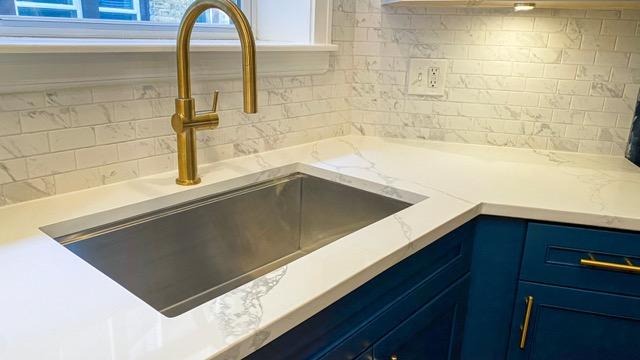 A modern kitchen featuring blue cabinets and a stylish gold sink creating a vibrant and elegant atmosphere